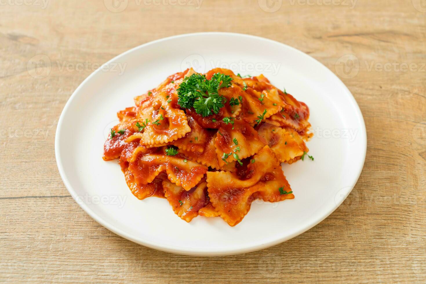 farfalle pasta in tomato sauce with parsley photo