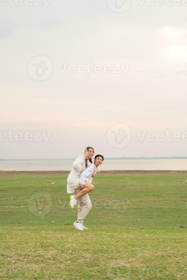 Happy young Asian couple in bride and groom clothing photo