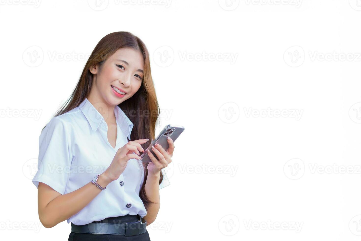 Portrait of cute Asian Thai girl student in uniform is standing work smiling and confidently while using smartphone in the building at university while isolated on white background. photo