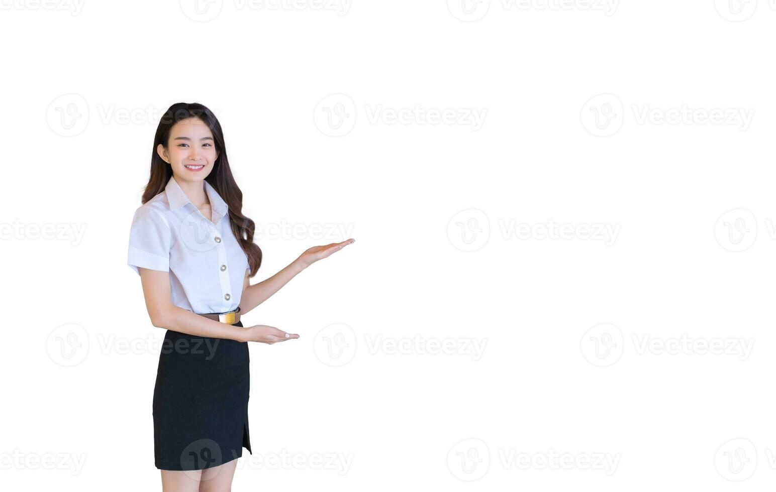 Portrait of adult Thai student. Beautiful Asian young woman student in uniform is smiling and looking at camera to present something confidently in university while isolated white background. photo