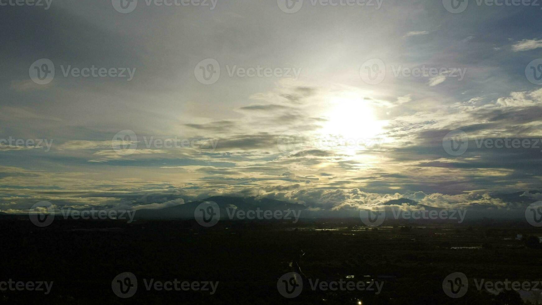 aéreo ver de el inundado agrícola campos en contra el antecedentes de el oscuridad de el montañas y el nublado cielo a oscuridad. hermosa naturaleza de tormenta nubes en el tiempo de día. foto