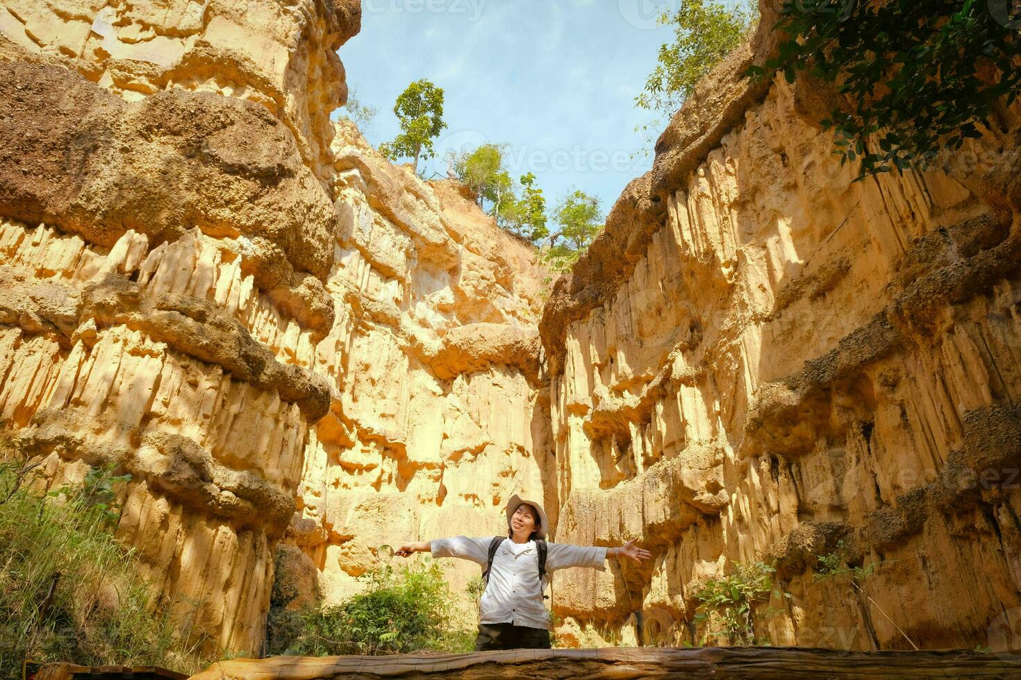 Female geologist with backpack exploring nature trail in forest and analyzing rock or gravel. Researchers collect samples of biological materials. Environmental and ecology research. photo