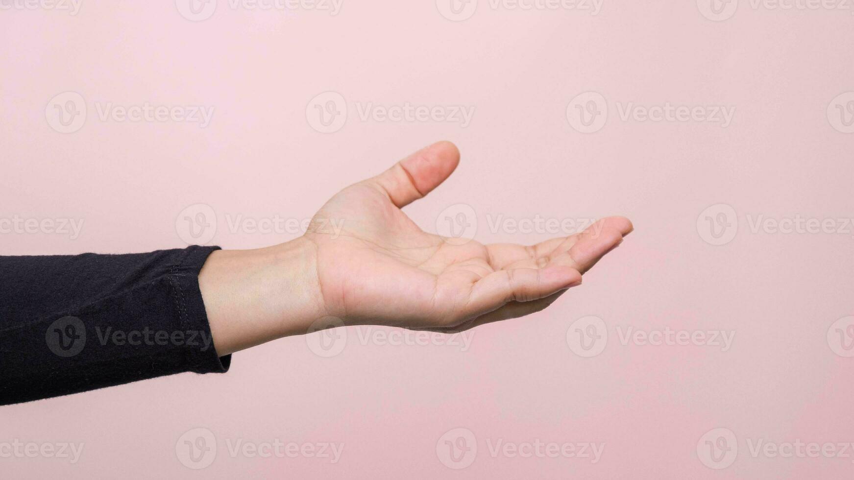 Close up of woman's hand reaching out ready to help or receive, isolated on pink background. Helping hand outstretched for salvation. photo