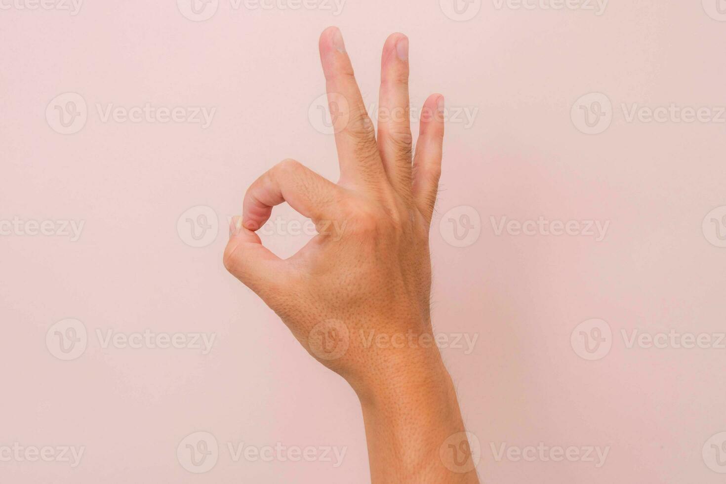 Female hand showing okay gesture isolated on pink background. photo