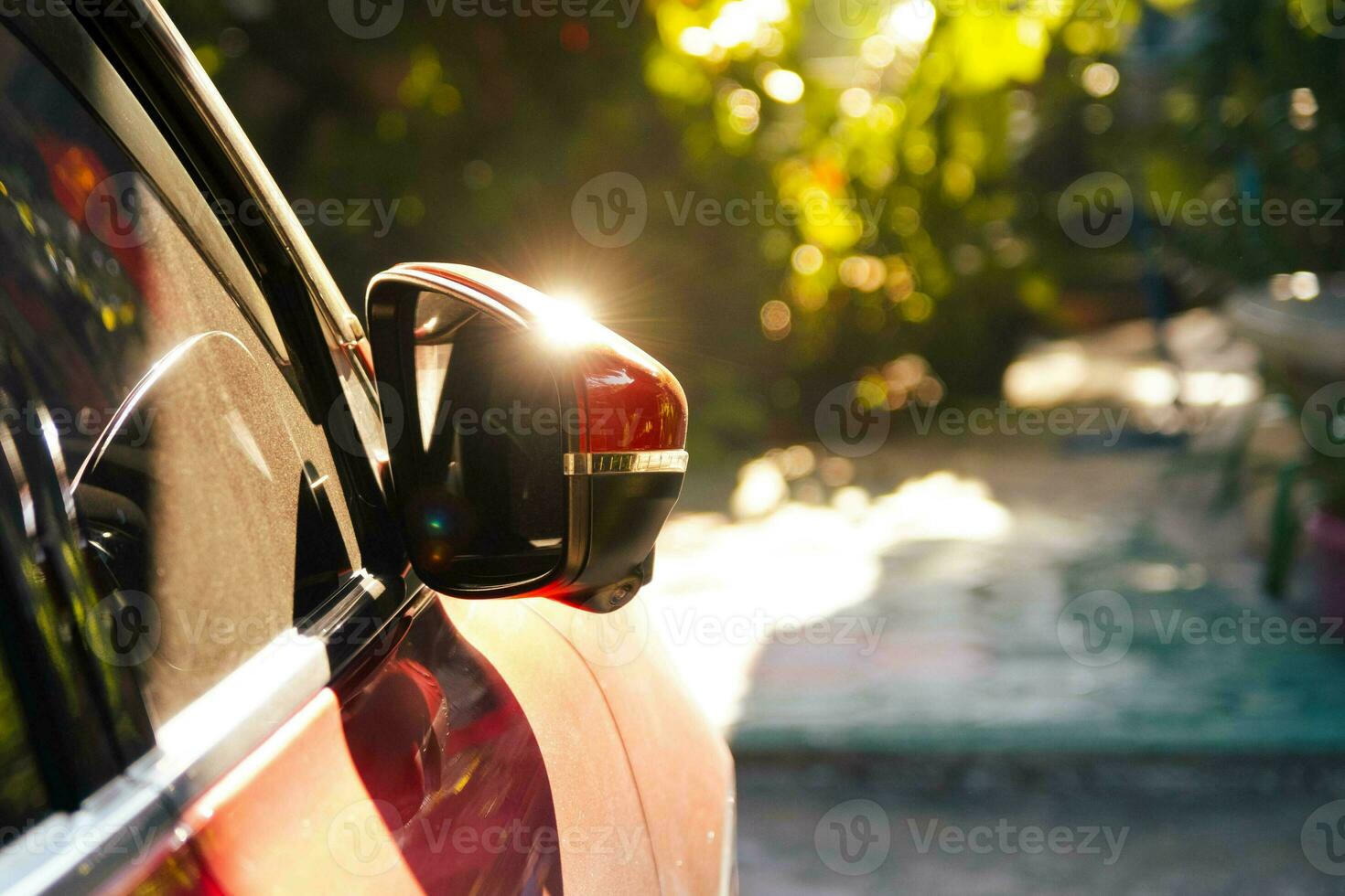 The sun shines down on the side mirror of the car. Sunlight reflected on the side mirror of a parked car. photo