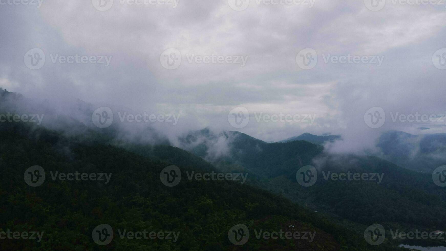 Aerial view of tropical forest with mist in the morning. Top view from drone of beautiful mountain tropical forest during winter in Thailand. Natural landscape background. photo