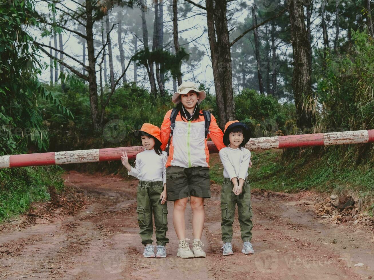 mujer joven feliz con su hija caminando juntos en un viaje de campo en las montañas. familia en una aventura de senderismo por el bosque. los padres enseñan a sus hijos sobre la naturaleza y las plantas. foto