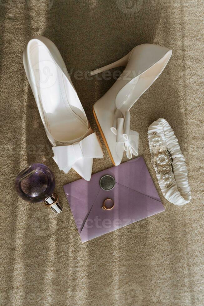 Stylish wedding composition with high-heeled shoes on a gray textile background. Flat lay, top view concept of festive wedding fashion. photo
