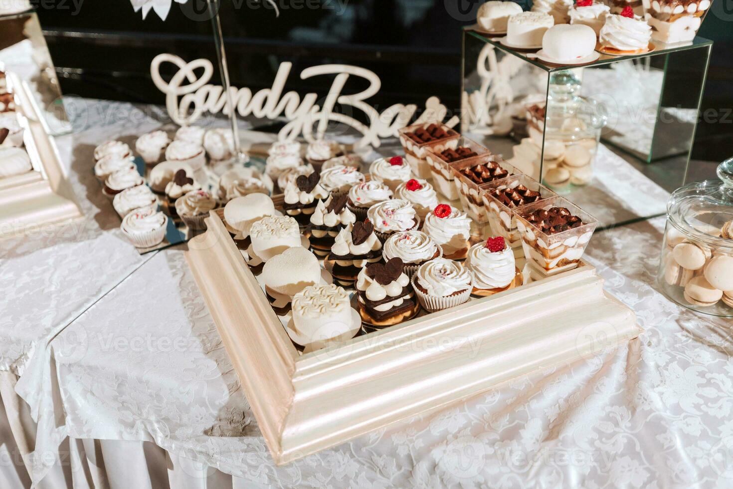 Festive dessert table with sweets. Wedding candy bar, various cakes, chocolates on stands. photo