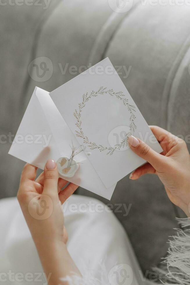 Close-up portrait of female hands holding a wedding invitation. Free space photo