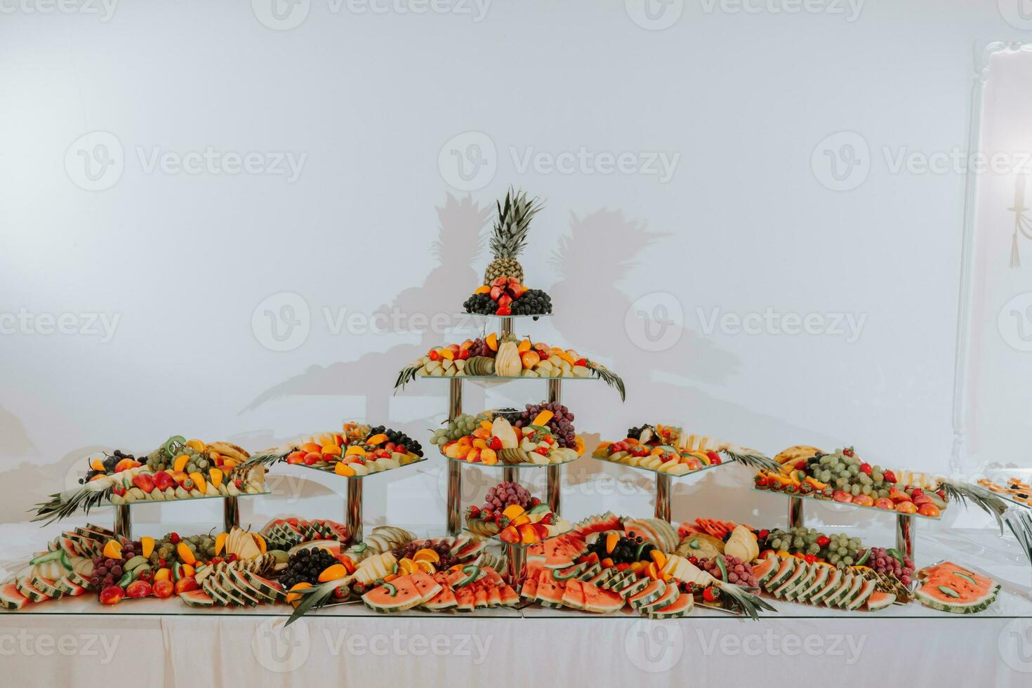 table with various fruit decorations. Watermelon carving, pineapple slices, grapes, orange photo