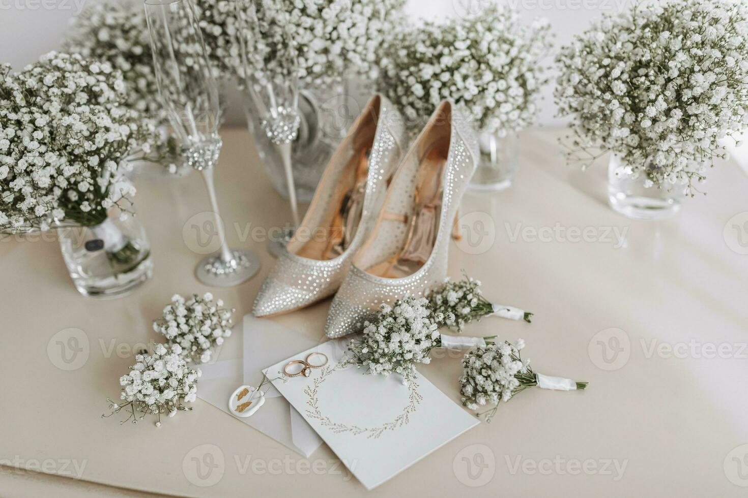 Wedding rings of the bride and groom with wedding bouquets of white flowers. Two beautiful gold wedding rings. Men's and women's rings with ornaments. Women's high-heeled shoes. place for text photo