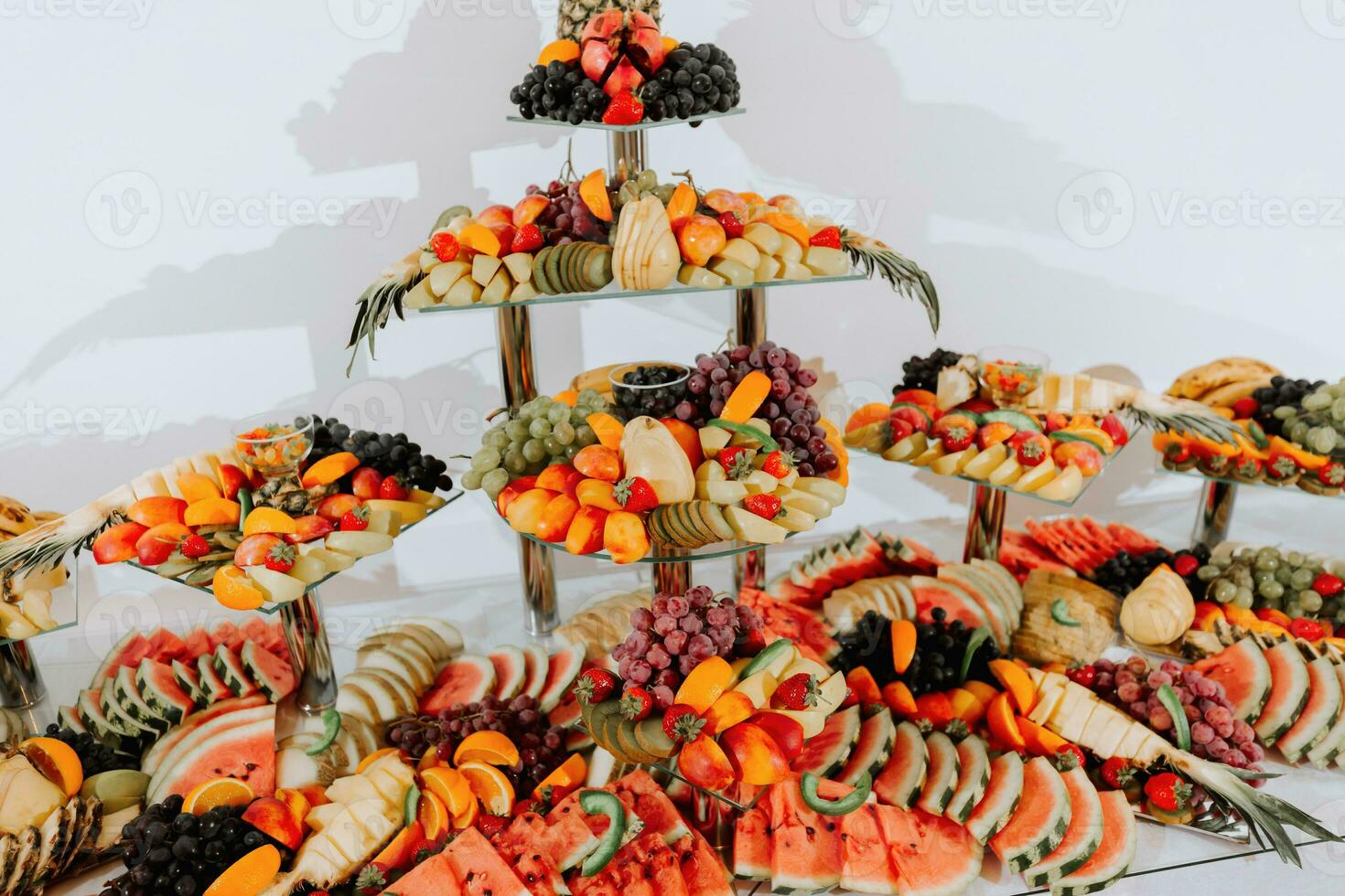 table with various fruit decorations. Watermelon carving, pineapple slices, grapes, orange photo