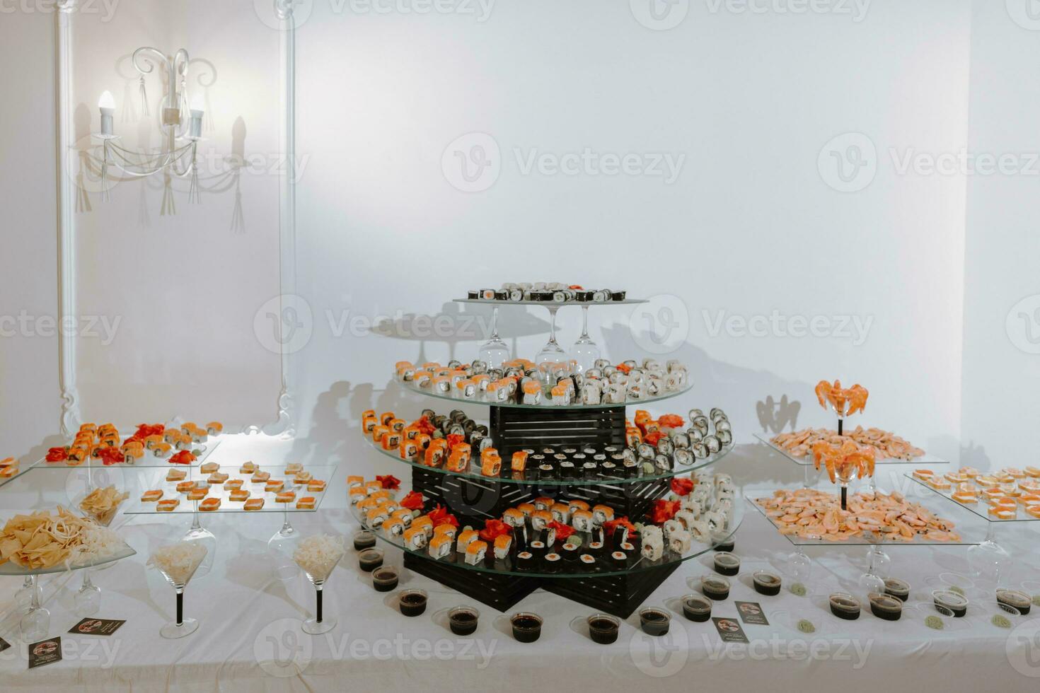 Big buffet reception of different delicious food at a wedding celebration. Snacks for guests. Wedding party. Canapes, sushi, fruit, meat, drink, wine, juice. photo