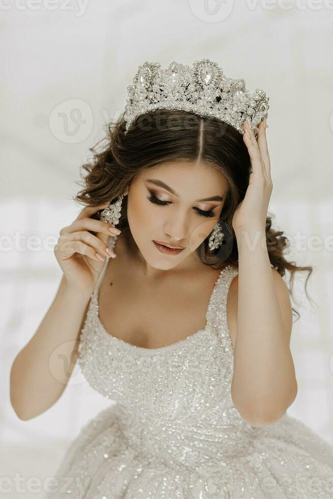 Top view, beautiful bride, with a white wedding dress and a luxurious tiara on her head photo