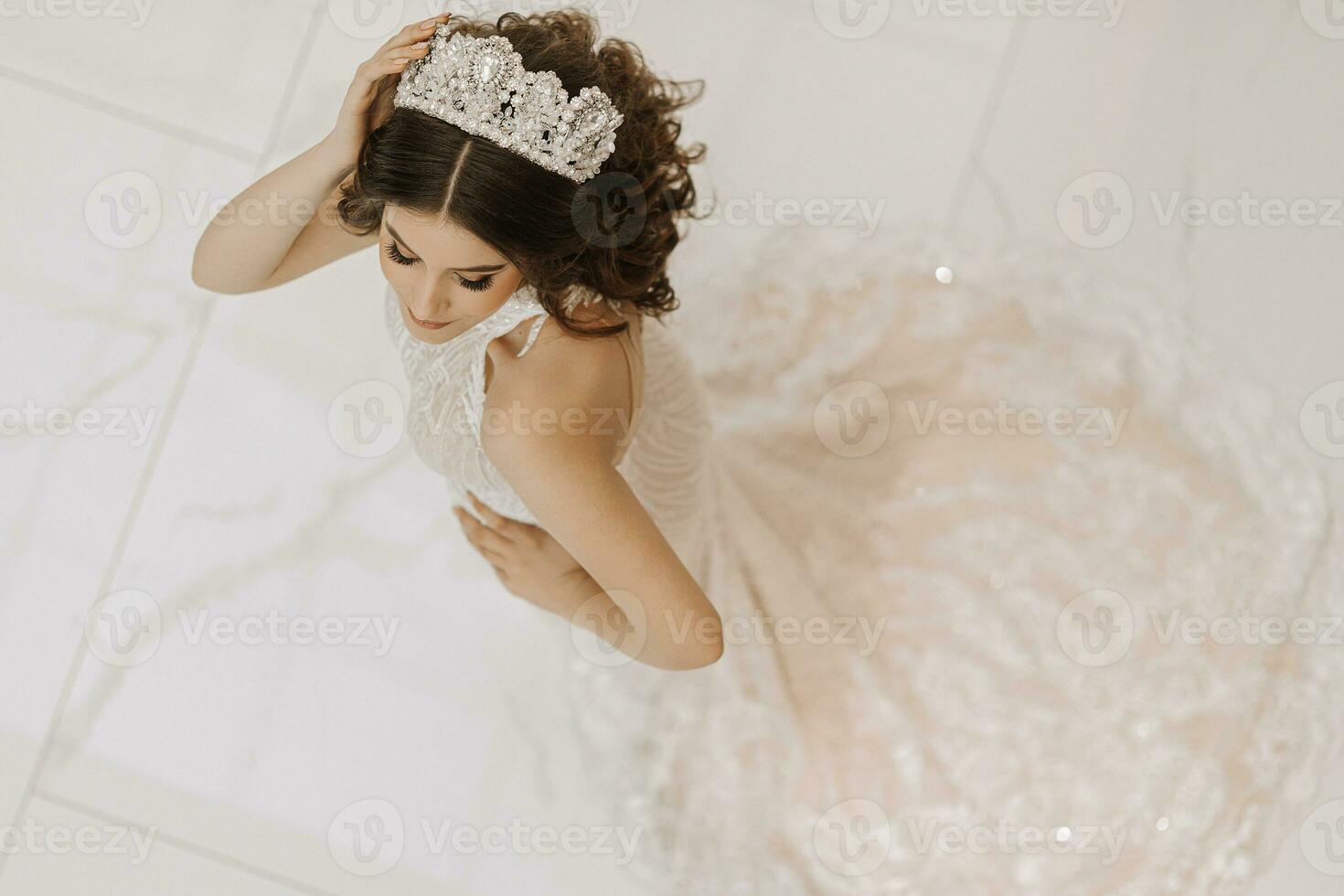 Top view, beautiful bride, with a white wedding dress and a luxurious crown on her head. Horizontal photo