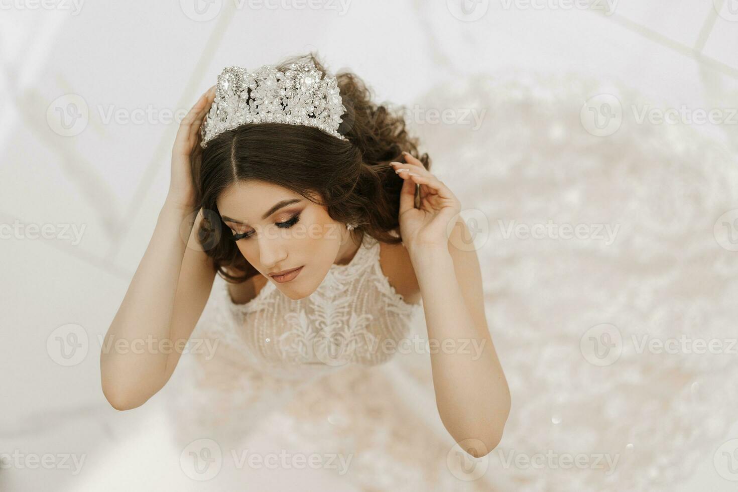 Top view, beautiful bride, with a white wedding dress and a luxurious crown on her head. Horizontal photo