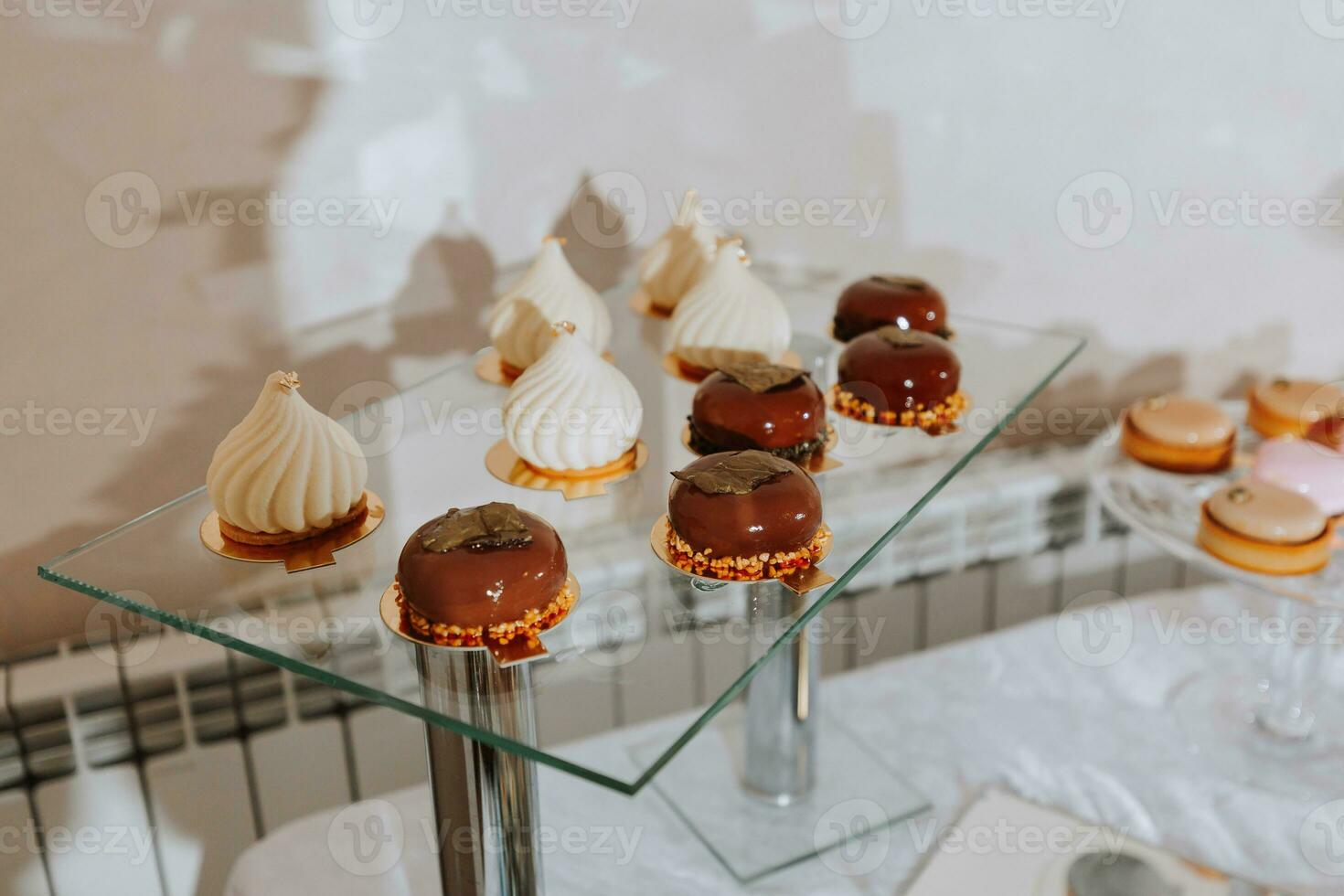 Festive dessert table with sweets. Wedding candy bar, various cakes, chocolates on stands. photo