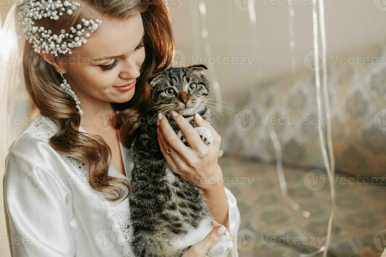 Young beautiful, blonde bride with a cat in her arms, in the morning before the wedding ceremony photo