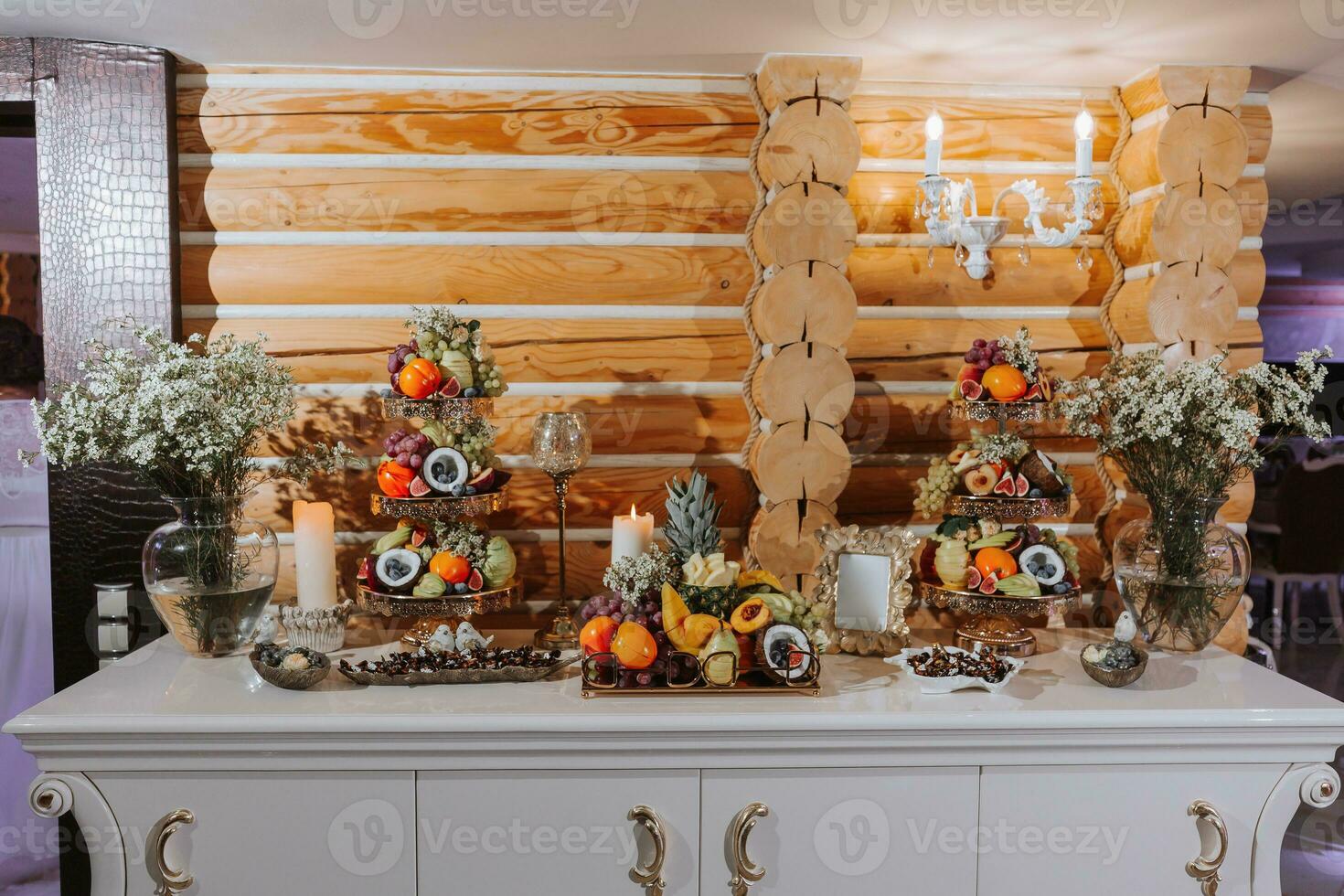 table with various fruit decorations. Watermelon carving, pineapple slices, grapes, orange photo