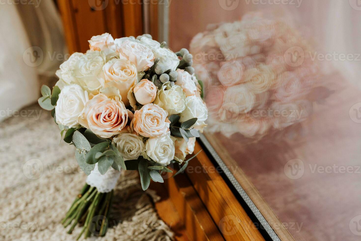 A wedding bouquet of pink and white roses near the window photo