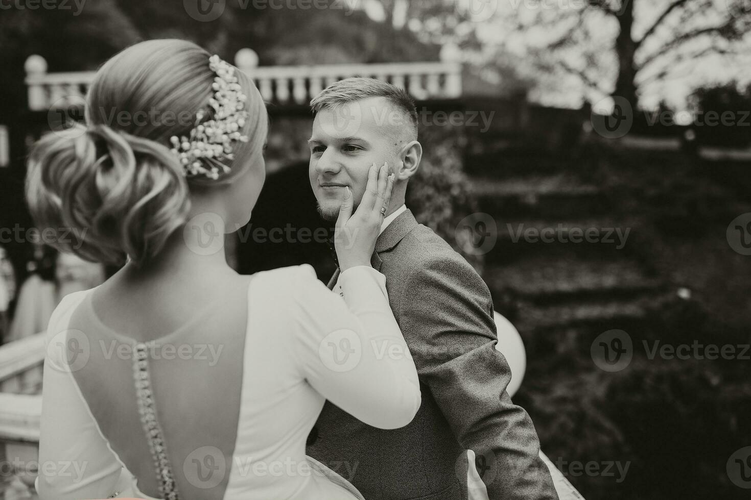 Tender look of the groom on his wife in a luxurious garden photo