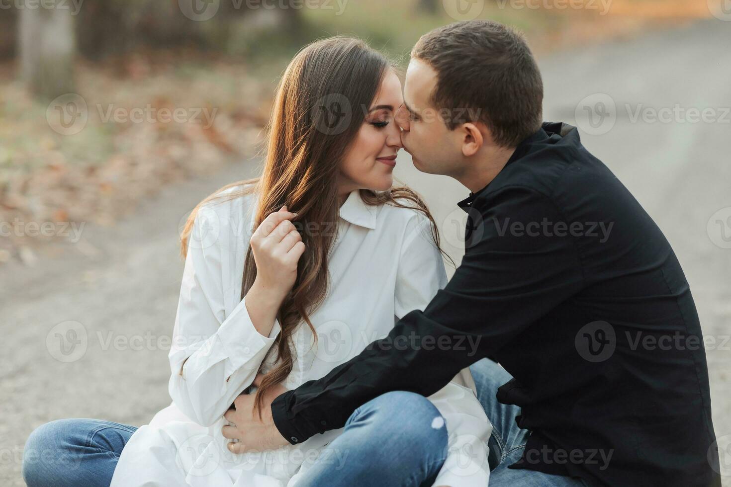 A man near his pregnant wife, resting in an autumn park. Support of the husband during pregnancy. The topic of mental health during pregnancy photo