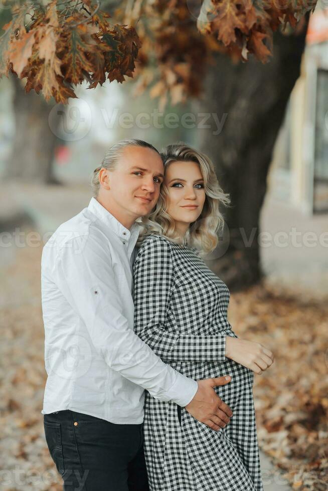 Attractive pregnant couple together on the street. Beautiful pregnant woman and her boyfriend in the city photo