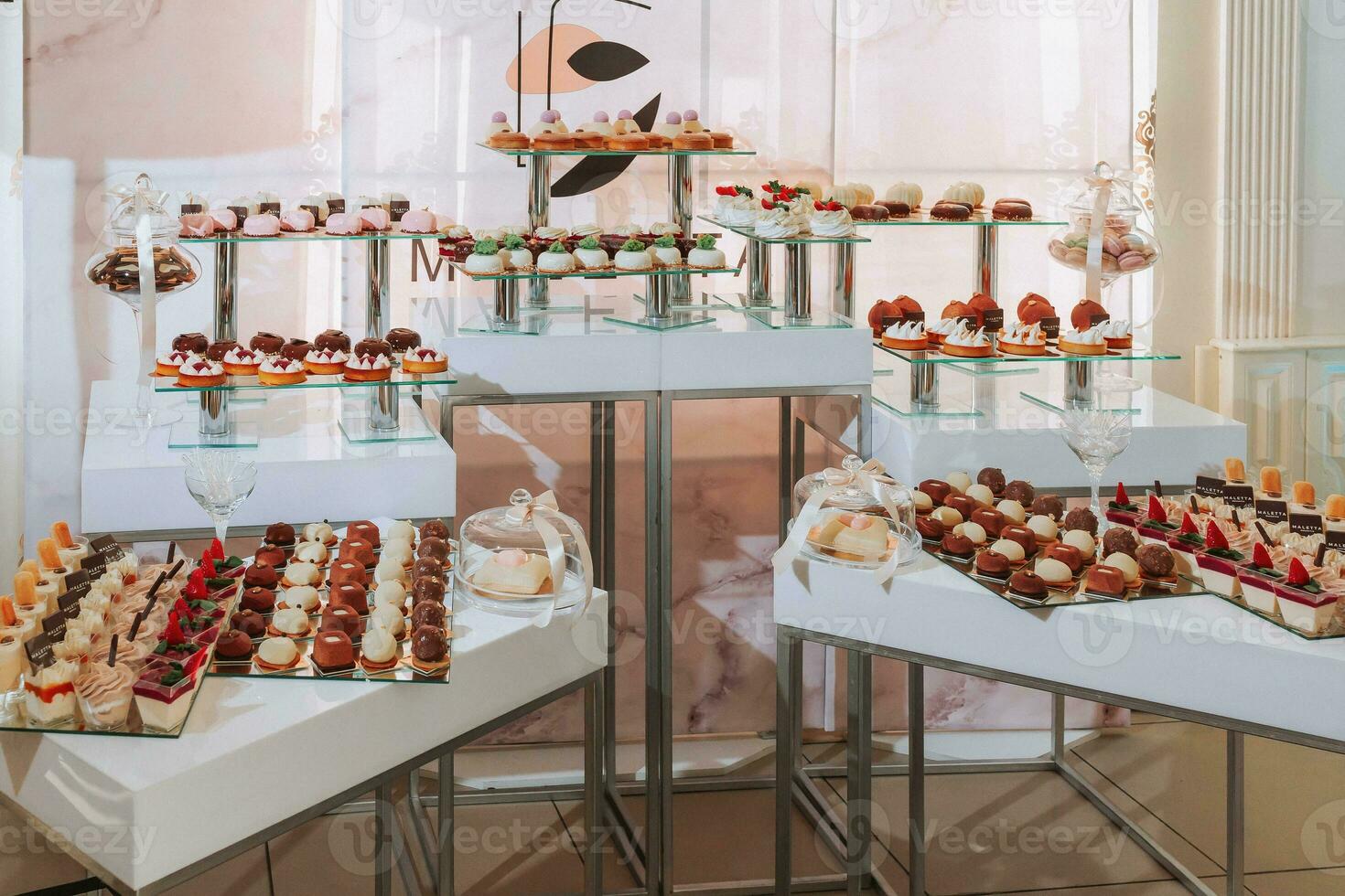 Festive dessert table with sweets. Wedding candy bar, various cakes, chocolates on stands. photo