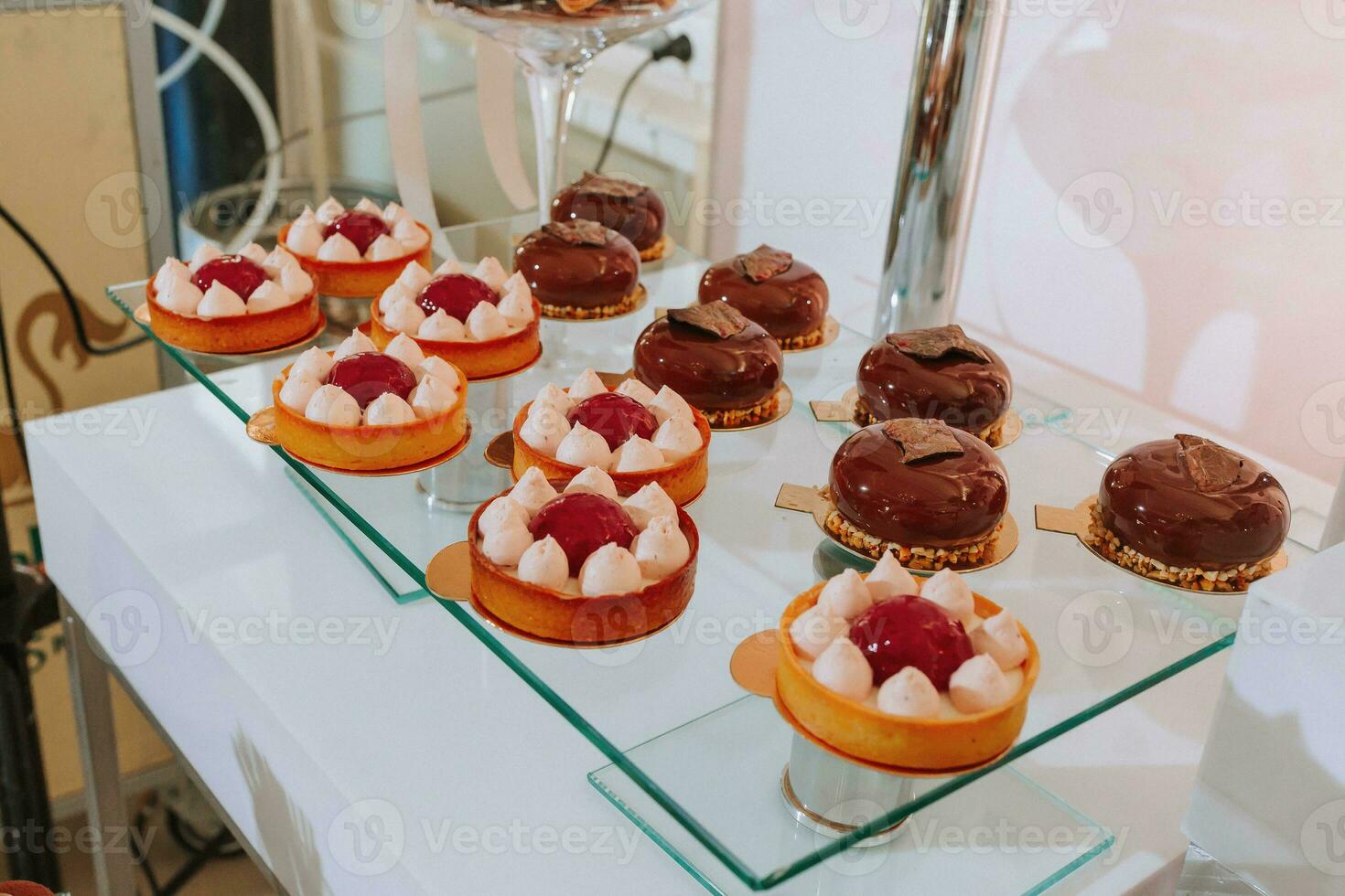 Festive dessert table with sweets. Wedding candy bar, various cakes, chocolates on stands. photo