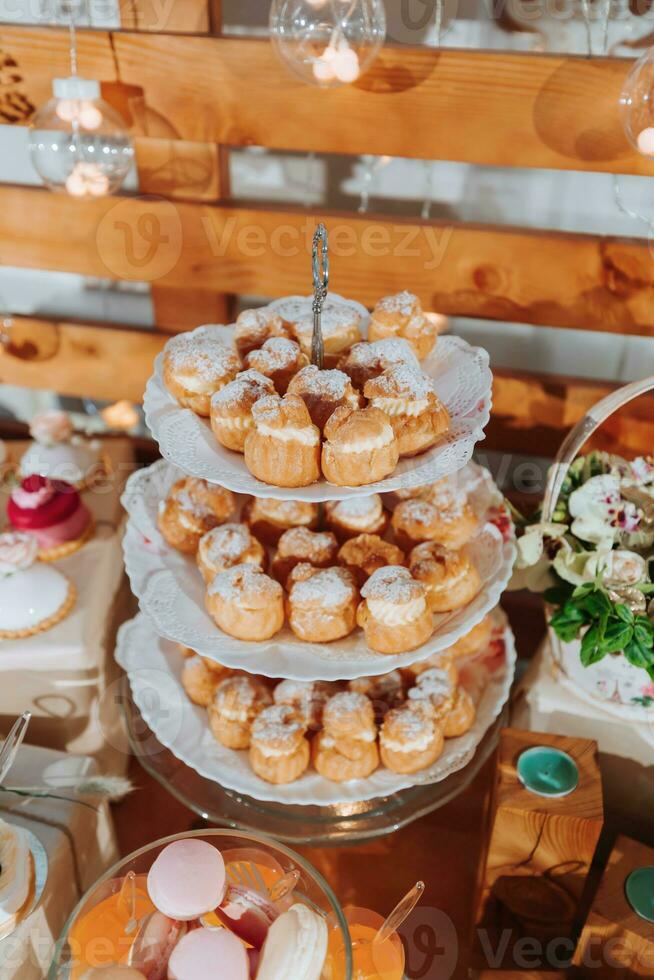 festivo postre mesa con dulces Boda caramelo bar, varios pasteles, chocolates en soportes foto