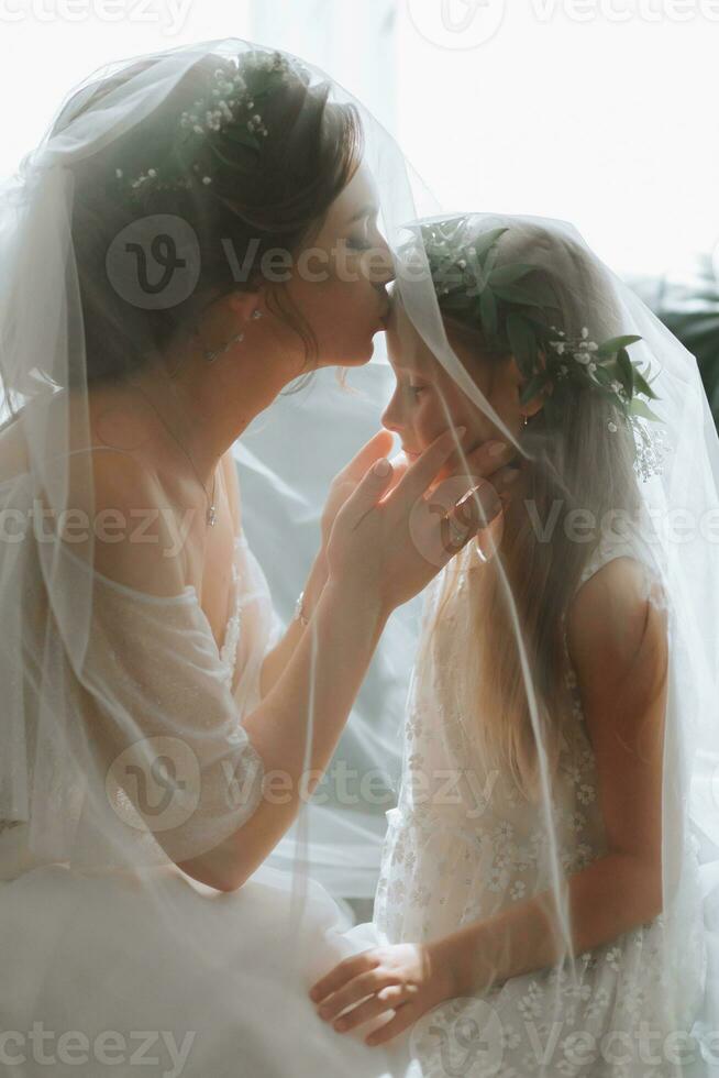 el novia y su hermana Mira a cada otro debajo el velo foto