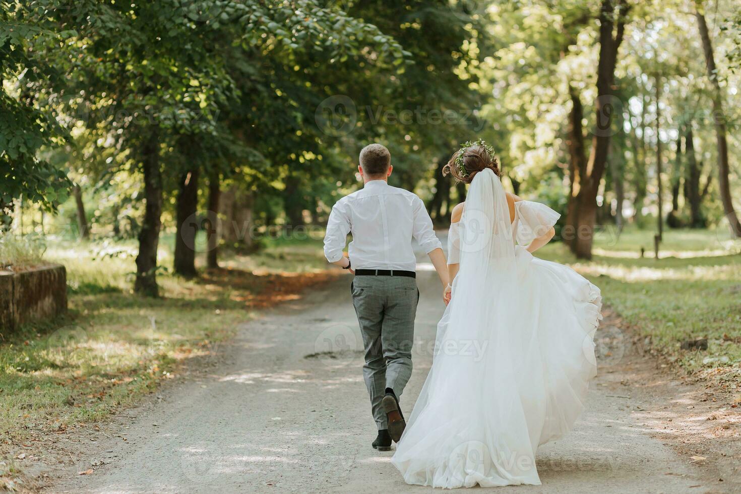 A wedding couple, a happy bride and groom are running in the park to the place of the wedding ceremony. Wedding concept photo