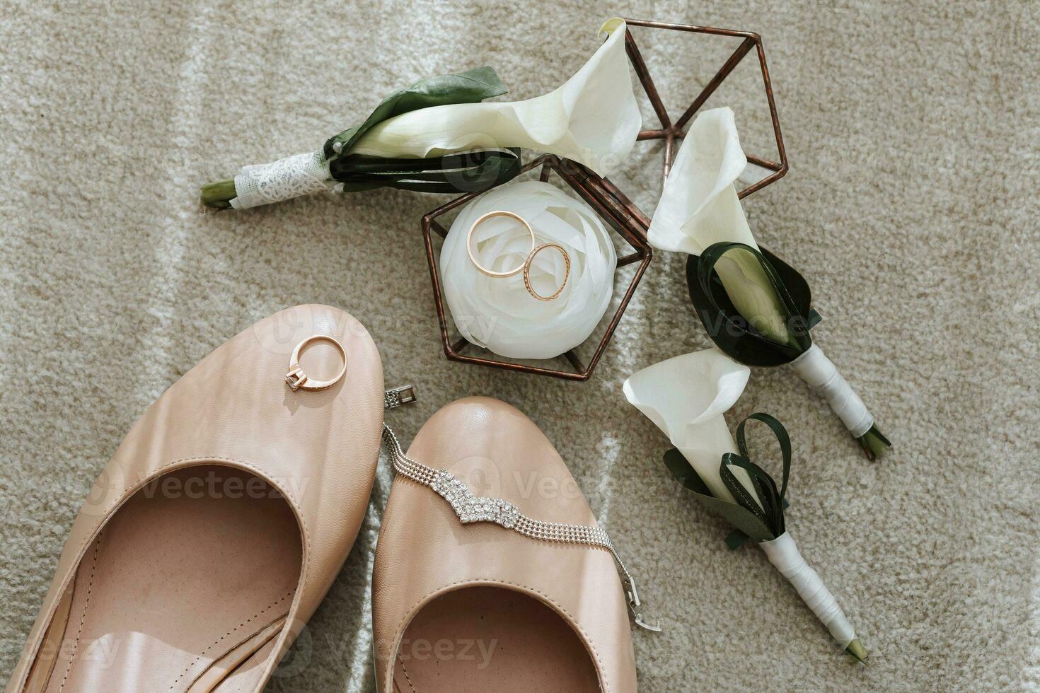 the bride's wedding shoes are beige, there are three calla flower boutonnieres and wedding rings in a glass box photo
