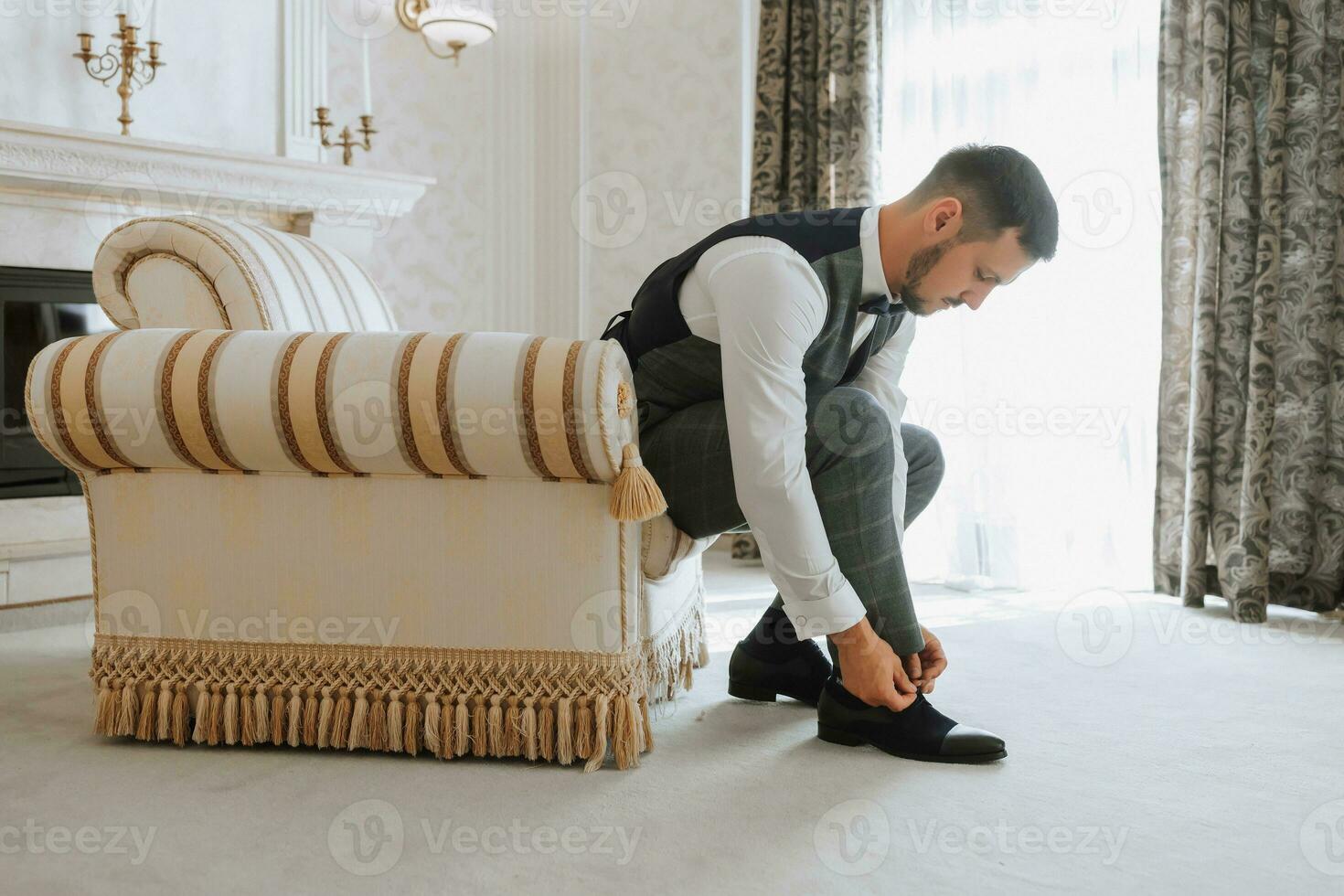 un elegante novio con un barba es preparando para el Boda ceremonia. del novio Mañana. el empresario usa negro zapatos. el novio es consiguiendo Listo en el Mañana antes de el Boda ceremonia foto