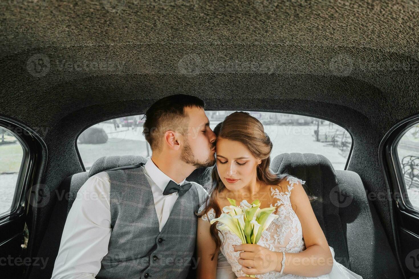 joven contento novia y novio en su coche alegrarse y Beso después el Boda ceremonia foto