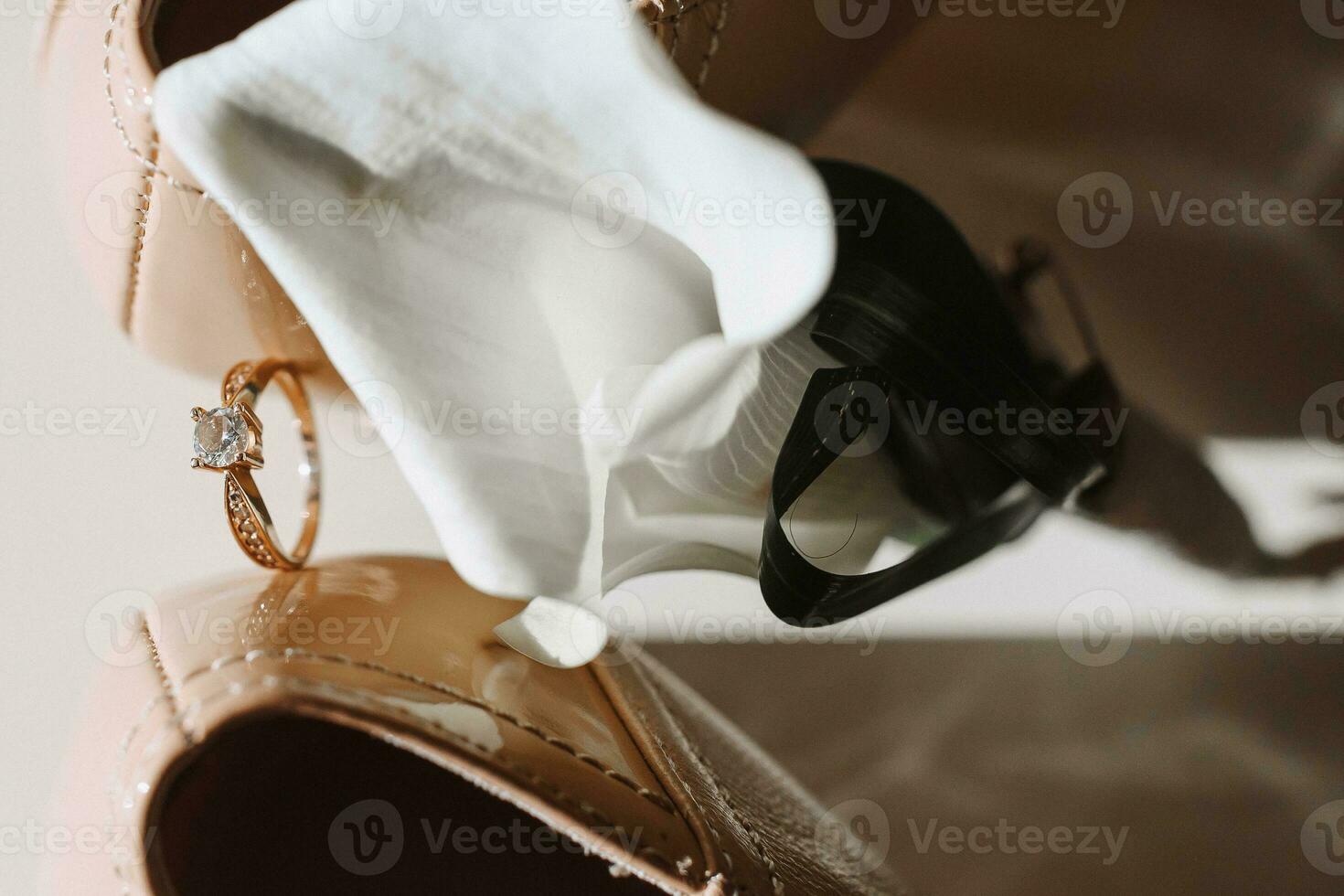a boutonniere of calla flowers and a gold wedding ring on a stand photo