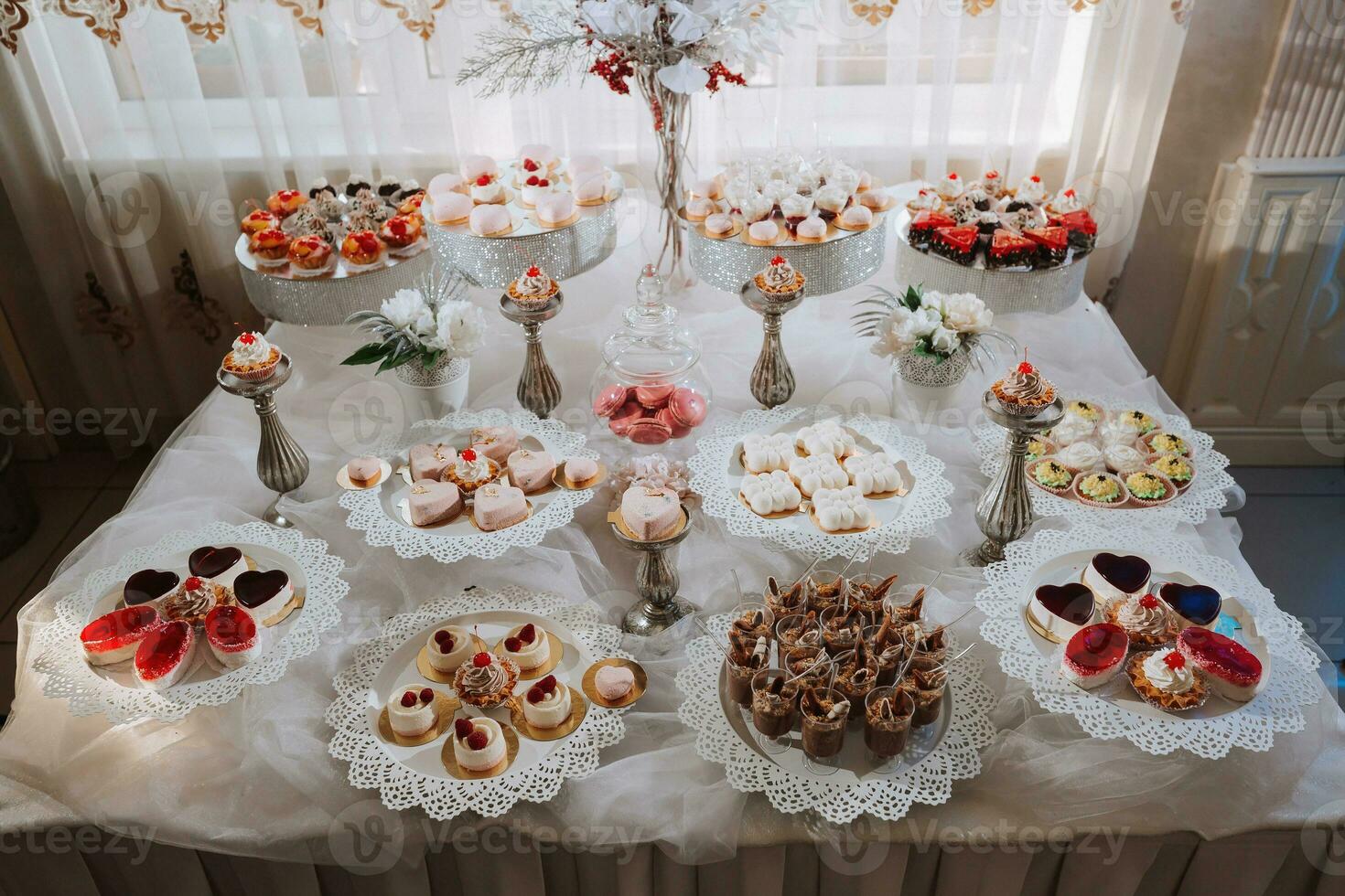 Festive dessert table with sweets. Wedding candy bar, various cakes, chocolates on stands. photo