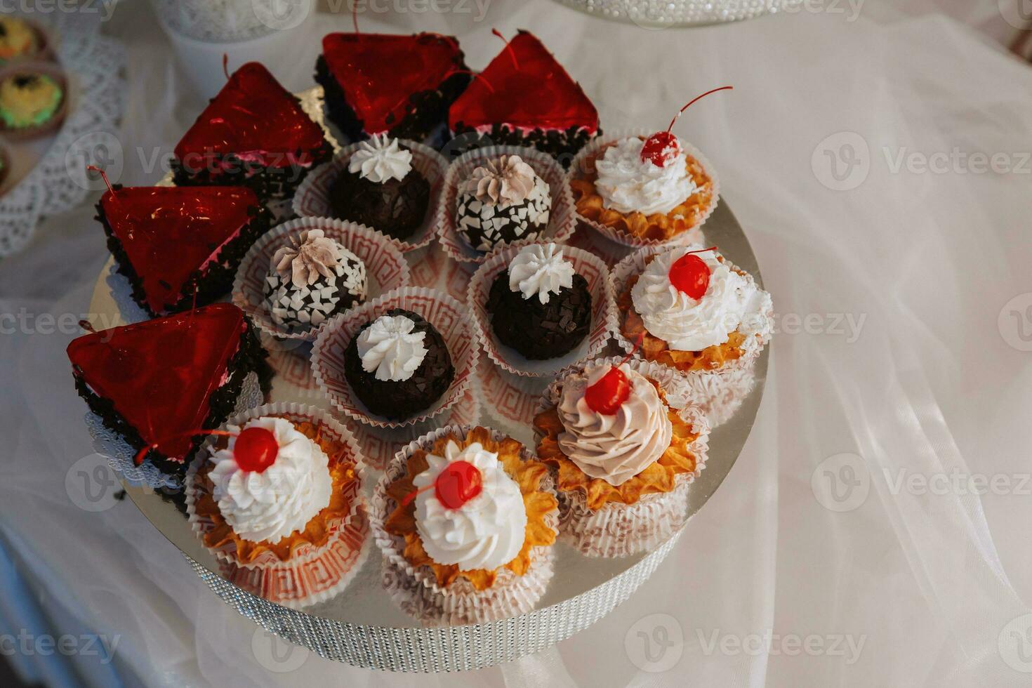 Festive dessert table with sweets. Wedding candy bar, various cakes, chocolates on stands. photo