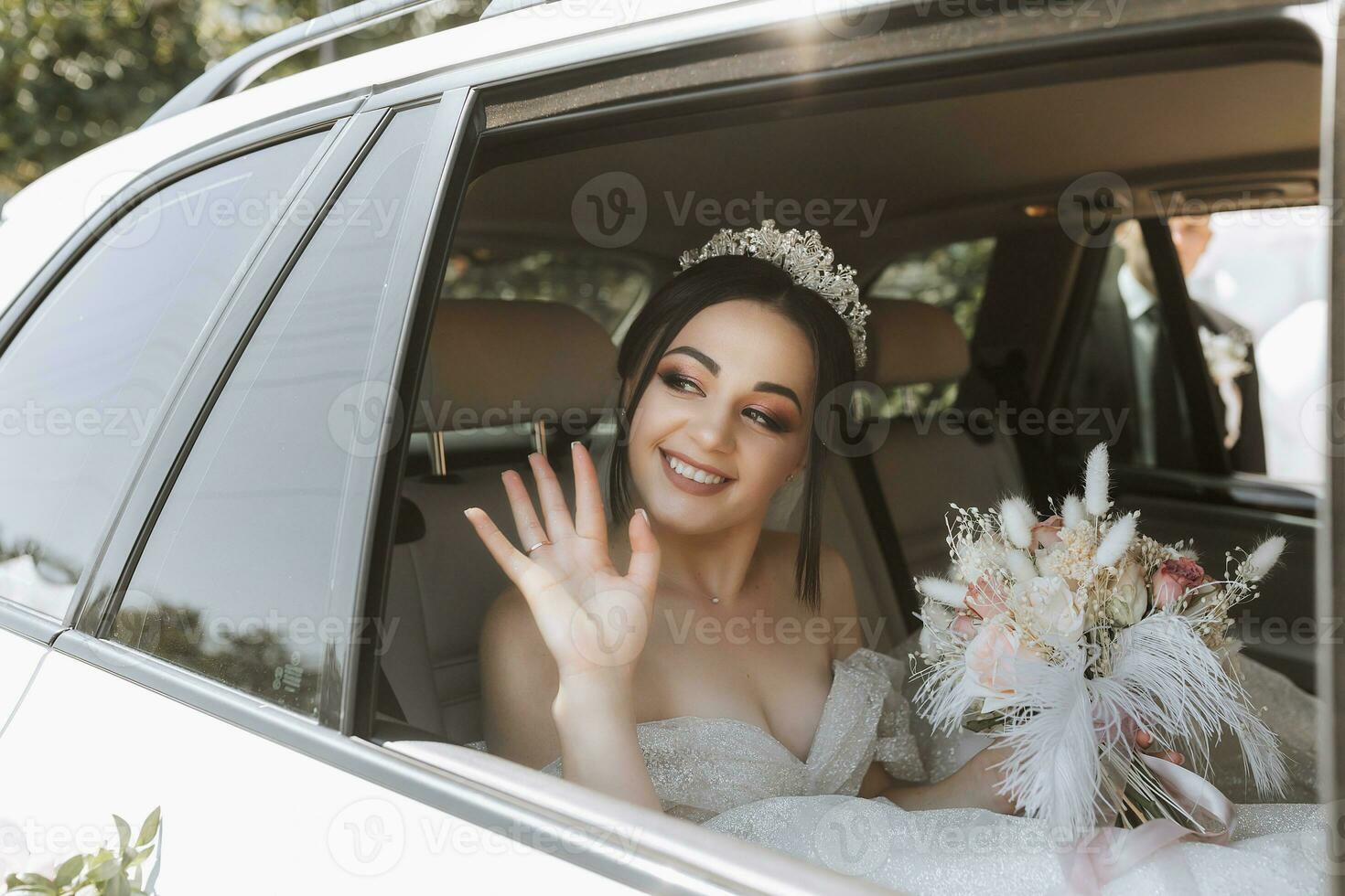 el novia se sienta en un blanco lujo coche en el Boda día con un ramo. retrato de el novia. lozano blanco cordón vestido. foto