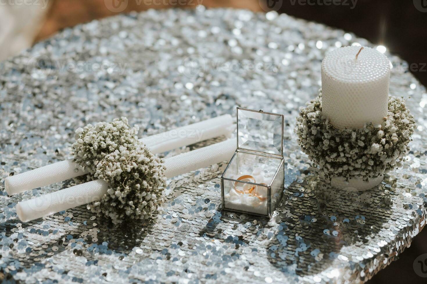 Boda accesorios antes de el Boda ceremonia. velas decorado con Gypsophila flores, Boda anillos para novias foto