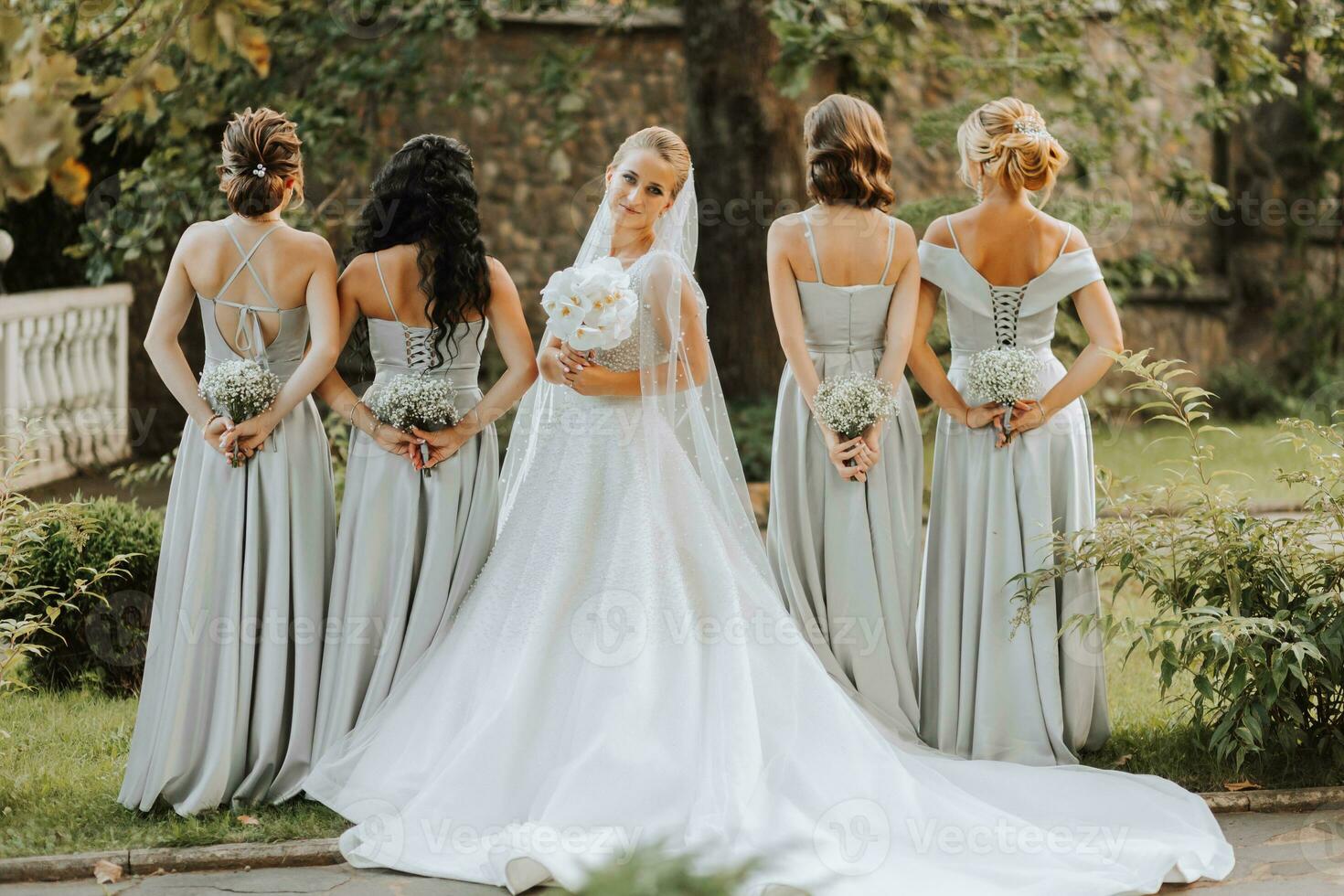 Group of beautiful girls with bride in matching dresses smiling, celebrating and having fun together. Girls party photo