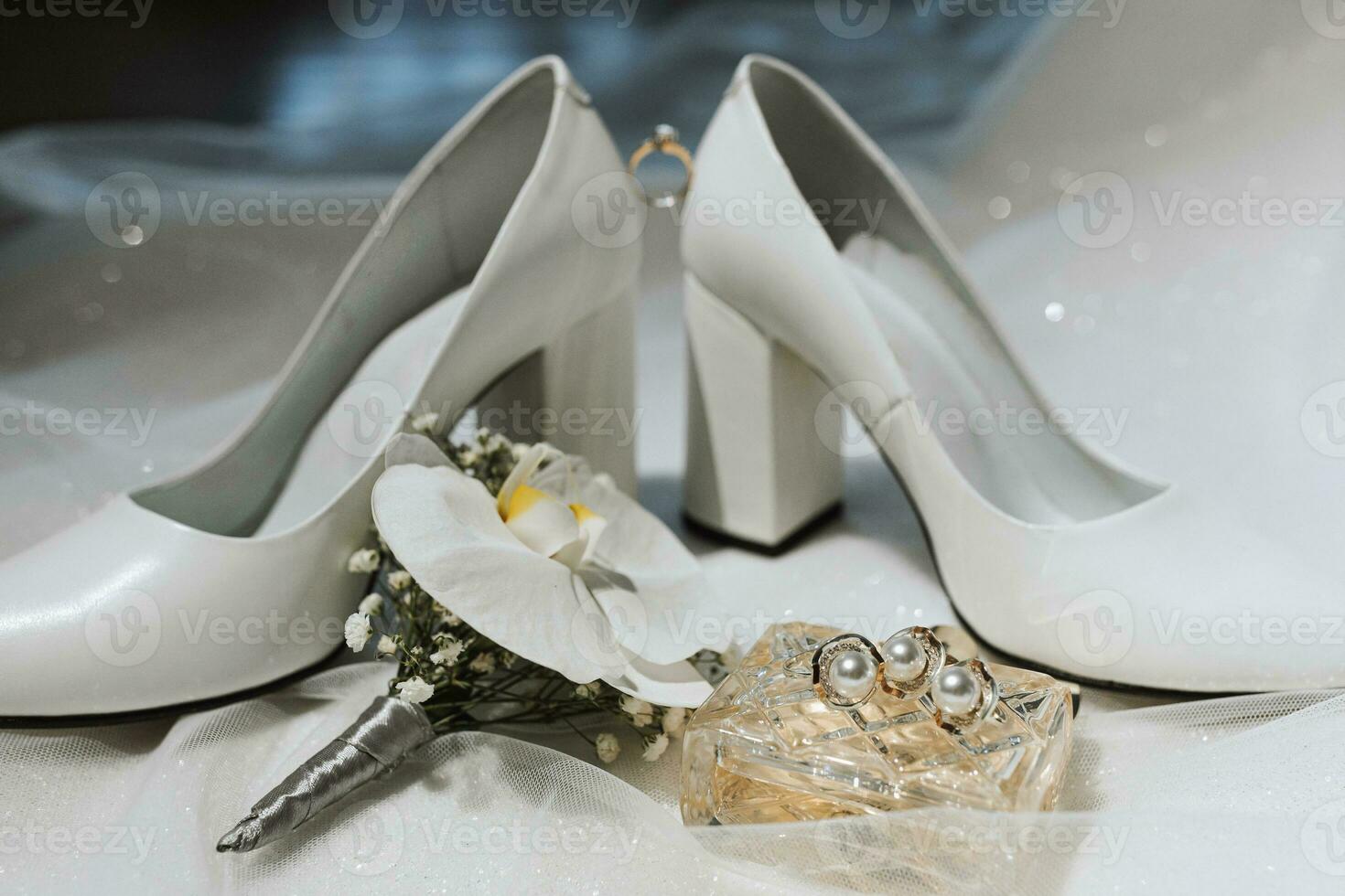 side view, closed women's white high-heeled shoes, perfume and bride's boutonniere. Women's engagement ring, wedding concept photo