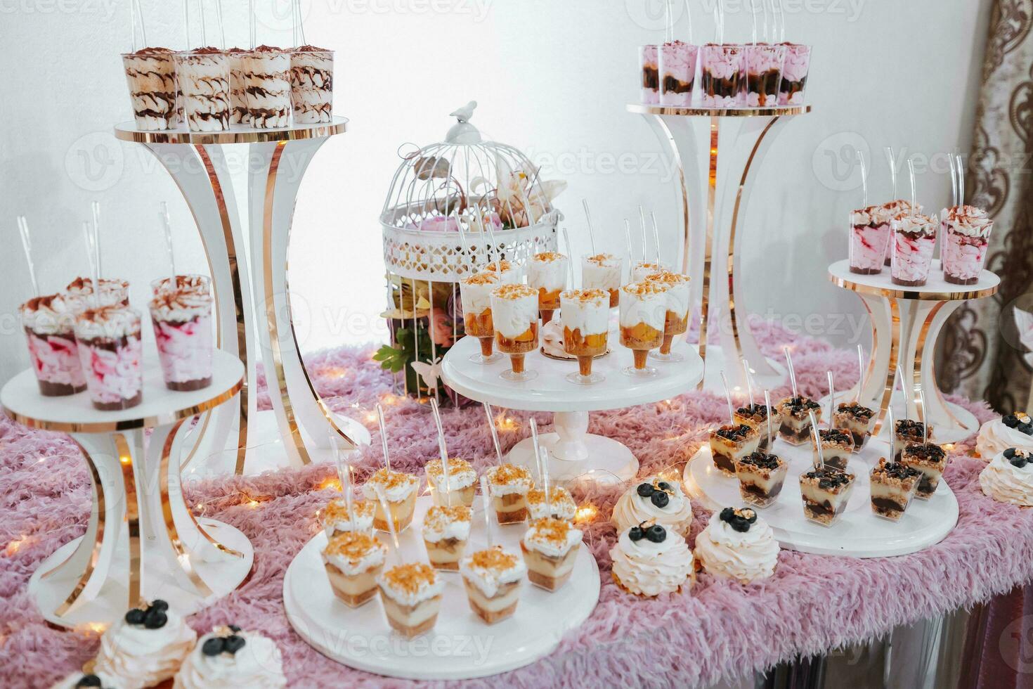 Festive dessert table with sweets. Wedding candy bar, various cakes, chocolates on stands. photo