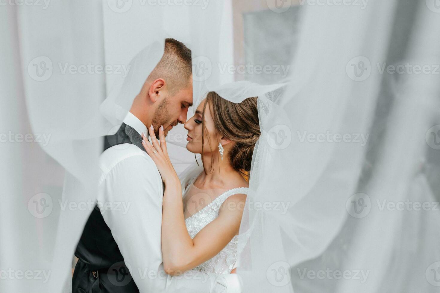 wedding couple on nature. bride and groom hugging under the veil at wedding. photo