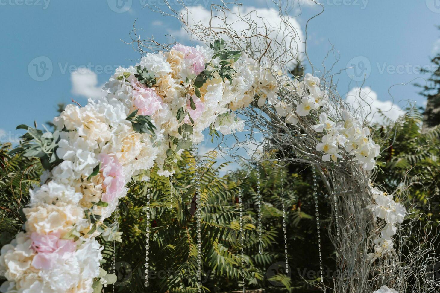 Wedding ceremony in the yard. Round arch of flowers and branches on a green background. Wedding theme. Holiday concept photo