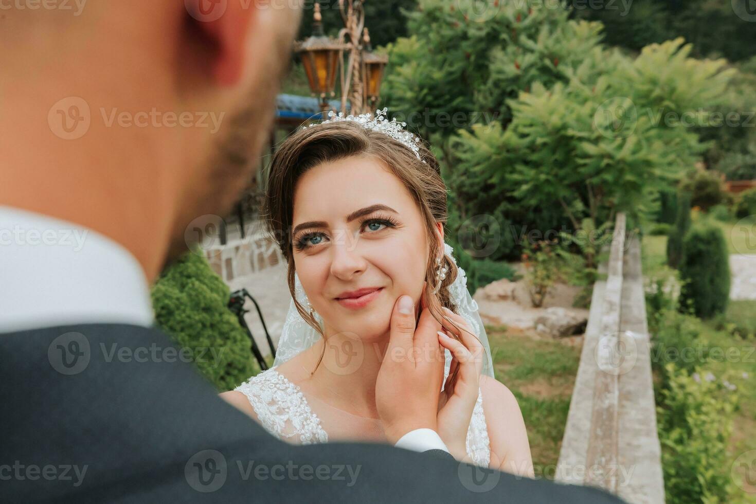 A wedding couple is enjoying the best day of their life against the background of green leaves in the park. Portrait of brides in love in nature photo