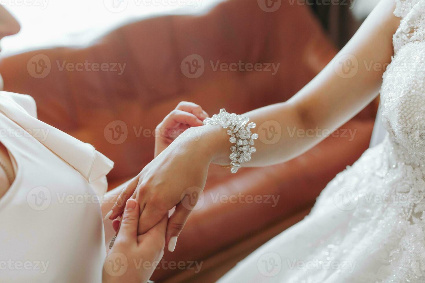 Wedding theme. A friend puts a bracelet on the bride. Four brunettes. The last minutes of preparations for the wedding. The same outfit photo