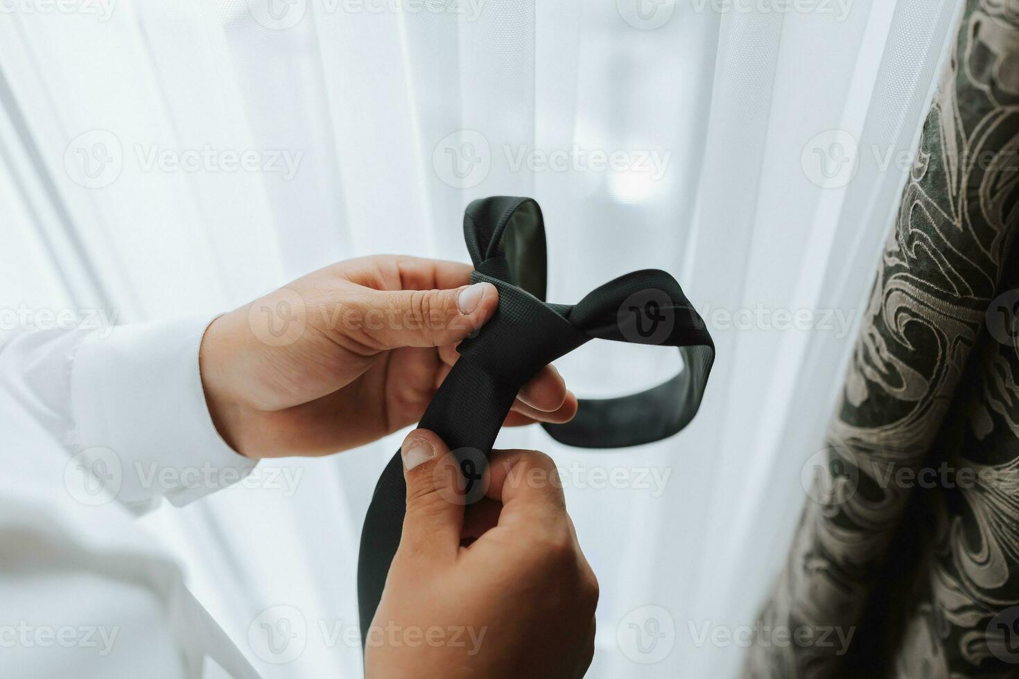 A stylish groom is preparing for the wedding ceremony. Groom's morning. Businessman in white shirt in hotel, male hands close-up, groom getting ready in morning before wedding ceremony photo