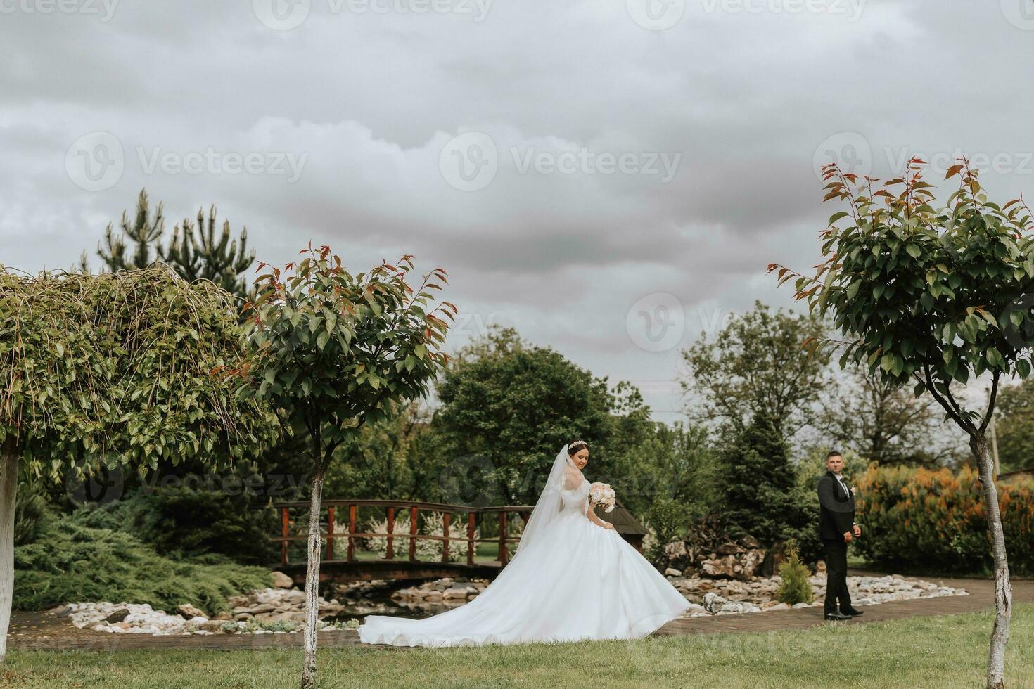 The bride and groom walk and walk towards each other. Wide-angle photo in an overcast sky.